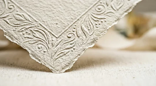 Détail d'une enveloppe de mariage élégante avec papier texturé haut de gamme sur fond neutre minimaliste