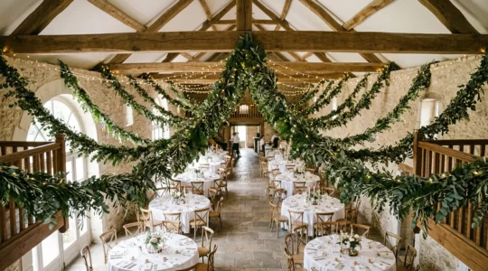Vue d'ensemble d'une salle de réception de mariage décorée de guirlandes suspendues créant une continuité visuelle harmonieuse